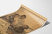 Historisk affisch – L’Alcool tue – Eugène Burnand, visad på ett böjt ark i perspektiv.