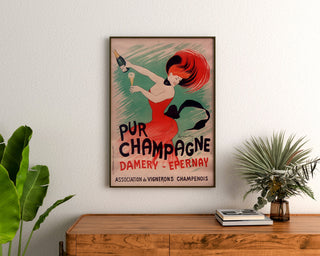 Vintageannons Champagne Damery-Épernay, inramad ovanför en träbyrå, mellan växter.