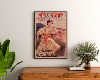Reklamaffisch vintage Paris–Niort, sommarnyheter, inramad ovanför en träbyrå, mellan växter.
