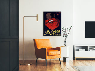 Vintage reklamaffisch Relskyr - 1° Kumel, inramad i ett vardagsrum med en orange fåtölj och en golvlampa.
