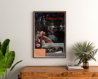 Vintage turistaffisch – Pougues-les-Eaux, PLM, inramad ovanför en träkommod, mellan växter.
