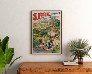 Vintage turistaffisch – Saint-Honoré-les-Bains, termalvatten, inramad ovanför en träkommod, mellan växter.