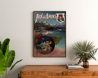 Vintage affisch Aix-les-Bains, nattfest, inramad ovanför en träbyrå, mellan växter.