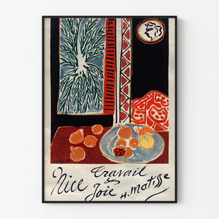 Vintageaffisch Nice, Travail et Joie, uppsatt i en tunn ram på en ljus vägg.