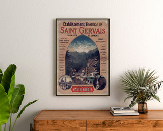 Vintageaffisch Saint-Gervais, kurort, inramad ovanför en träbyrå, mellan växter.