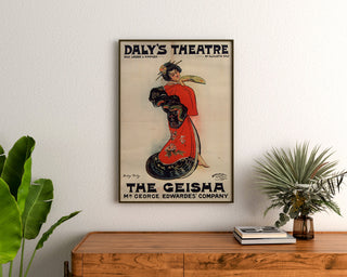 Vintageaffisch The Geisha, Daly’s Theatre, inramad ovanför en träbyrå mellan växter.
