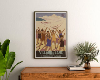 Vintageaffisch Villard-de-Lans, SNCF, inramad ovanför en träbyrå, mellan växter.